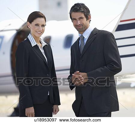 Stock Photo - Two business colleagues standing by a plane. Fotosearch