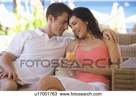 A couple relaxing with a drink on holiday View Large Photo Image Stock Image - A couple relaxing with a drink on holiday. Fotosearch
