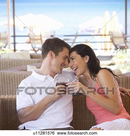 A couple relaxing with a drink on holiday View Large Photo Image Stock Photograph - A couple relaxing with a drink on holiday. Fotosearch