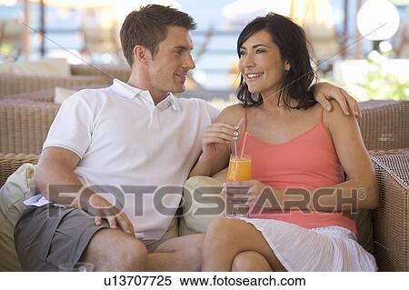 A couple relaxing with a drink on holiday View Large Photo Image Stock Photography - A couple relaxing with a drink on holiday. Fotosearch