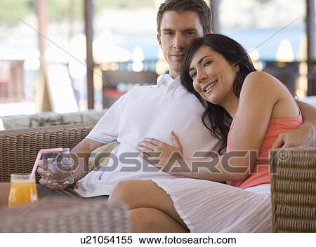 Stock Photography - A couple relaxing with a drink on holiday. Fotosearch