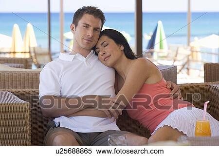 A couple relaxing with a drink on holiday View Large Photo Image Stock Photography - A couple relaxing with a drink on holiday. Fotosearch