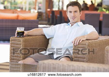 A man relaxing with a drink on holiday View Large Photo Image Stock Photo - A man relaxing with a drink on holiday. Fotosearch