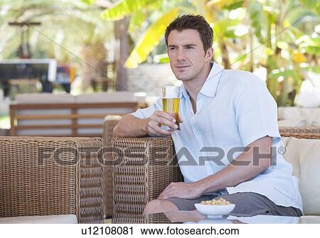 Stock Image - A man relaxing with a drink. Fotosearch