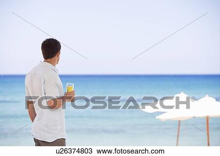 Stock Image - A man relaxing with a drink. Fotosearch