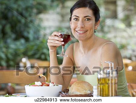 A woman drinking a glass of wine with a meal View Large Photo Image Stock Image - A woman drinking a glass of wine with a meal. Fotosearch