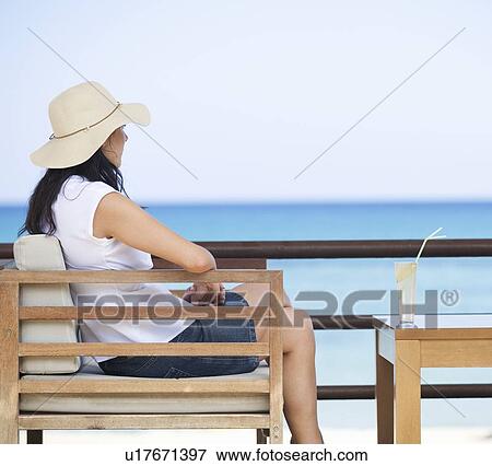 A woman relaxing with a drink View Large Photo Image Stock Photo - A woman relaxing with a drink . Fotosearch