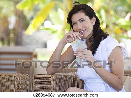 Stock Photo - A woman relaxing with a drink. Fotosearch