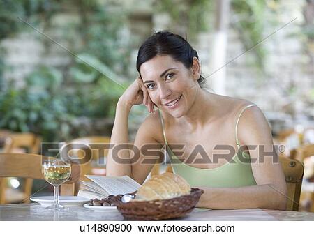 A woman sitting alone in a restaurant View Large Photo Image Stock Image - A woman sitting alone in a restaurant. Fotosearch