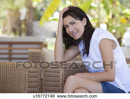 Stock Photo - A woman sitting in a chair. Fotosearch