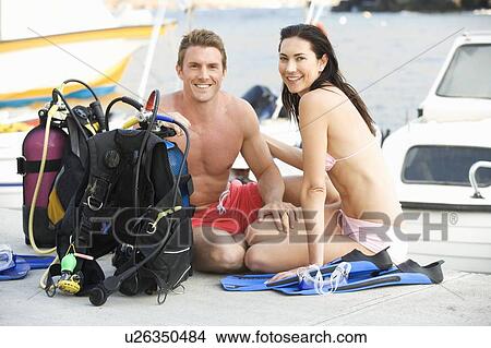Picture - A couple checking their scuba diving equipment. Fotosearch