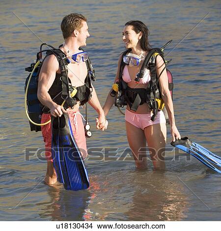 Picture - A couple returning from scuba diving. Fotosearch