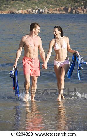 A couple walking on a beach View Large Photo Image Stock Image - A couple walking on a beach. Fotosearch