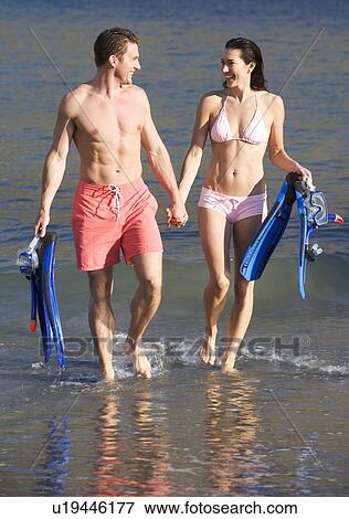 A couple walking on a beach View Large Photo Image Stock Photo - A couple walking on a beach. Fotosearch