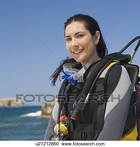 Stock Image - A female scuba diver sitting on a boat. Fotosearch