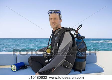 A man sitting on a boat preparing to go scuba diving View Large Photo Image Stock Image - A man sitting on a boat preparing to go scuba diving. Fotosearch