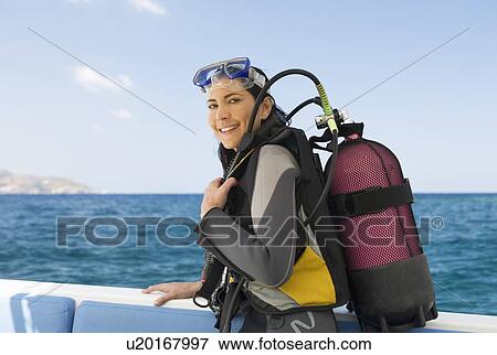 Stock Photo - A woman about to go scuba diving. Fotosearch