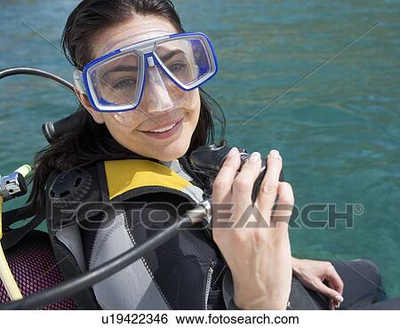 Stock Photograph - A woman about to go scuba diving. Fotosearch