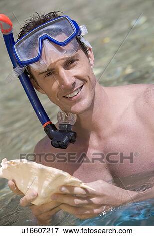 A male snorkeler holding a shell View Large Photo Image Stock Photo - A male snorkeler holding a shell. Fotosearch