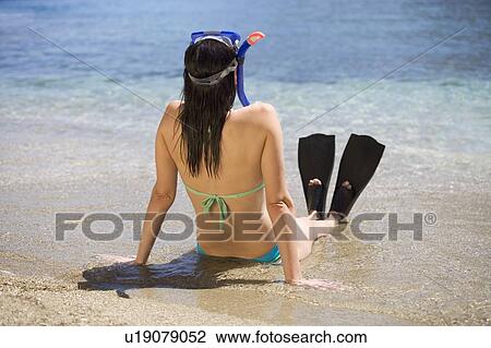 A woman wearing snorkeling equipment sitting on a beach View Large Photo Image Stock Image - A woman wearing snorkeling equipment sitting on a beach. Fotosearch
