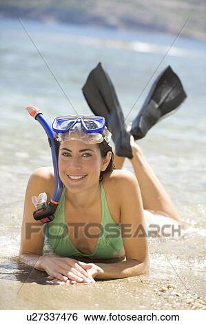 A woman wearing snorkeling equipment lying on a beach View Large Photo Image Stock Photograph - A woman wearing snorkeling equipment lying on a beach. Fotosearch