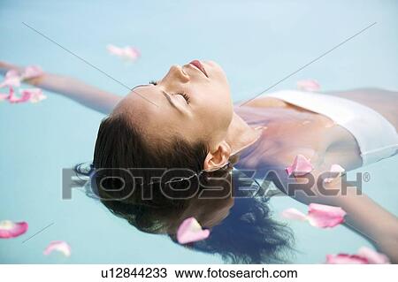 Stock Image - A woman floating in a pool. Fotosearch