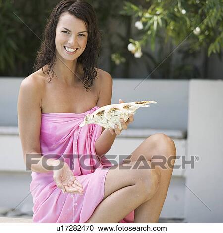 Stock Image - A young woman holding a large shell. Fotosearch