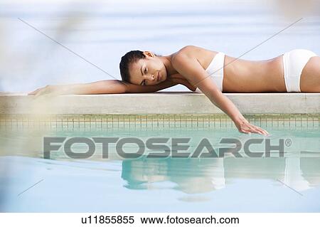 A young woman laying by a pool View Large Photo Image Stock Photography - A young woman laying by a pool. Fotosearch