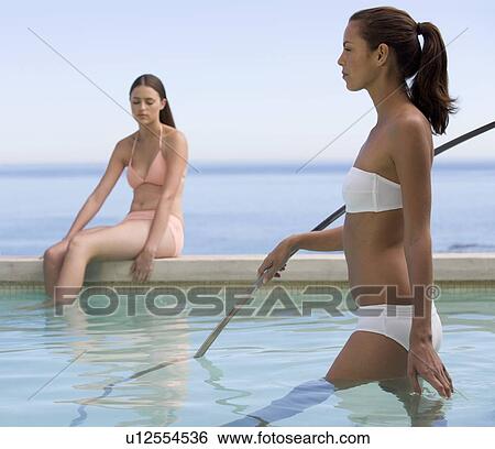 Two young women in a swimming pool View Large Photo Image Stock Photograph - Two young women in a swimming pool. Fotosearch