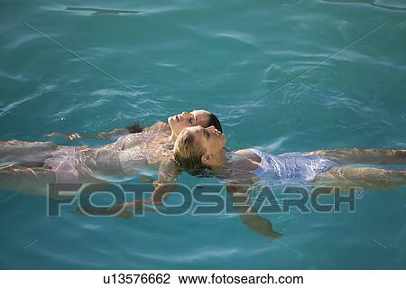 Stock Image - Two young women swimming in a pool. Fotosearch