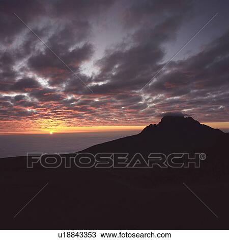 Stock Image - Sunrise above clouds at 5000 meters - mt Kilimanjaro. Fotosearch