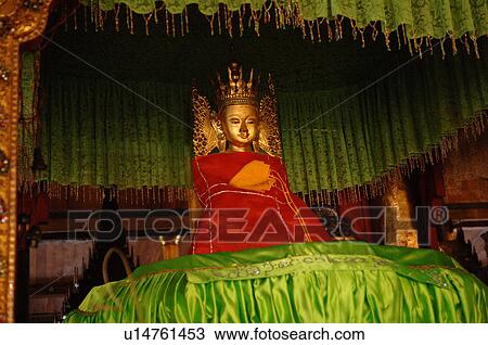 Stock Image - Buddha under a green canopy. Fotosearch