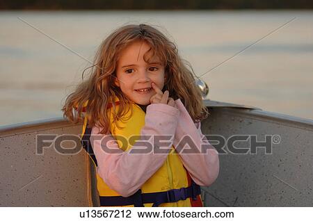 Stock Image - Blond girl in yellow lifejacket. Fotosearch