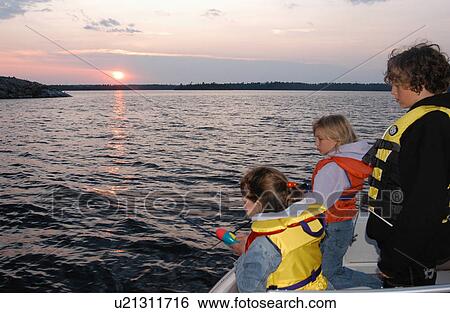Stock Photograph - Three young children in a motorboat. Fotosearch