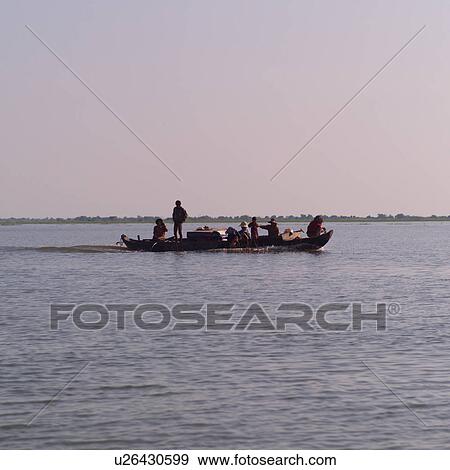 Stock Photo - Boat with people and cargo on the lake. Fotosearch