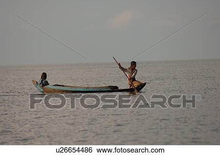 Stock Photograph - People on a canoe in Cambodia. Fotosearch