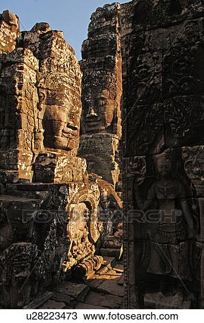 Stock Image - Stone carving of a face on wall at Khmer Kingdom palace ruins. Fotosearch