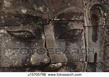 Stone carving of a face on wall at Khmer Kingdom palace ruins View Large Photo Image Stock Photo - Stone carving of a face on wall at Khmer Kingdom palace ruins. Fotosearch
