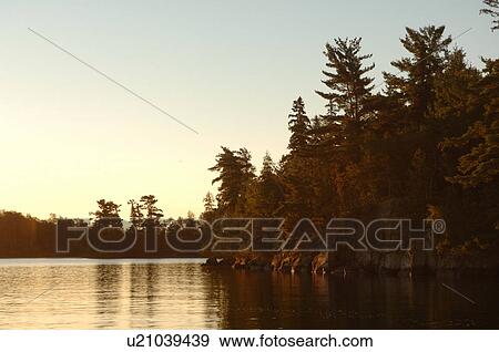 Stock Photo - Silhouette of shoreline against twilight sky. Fotosearch