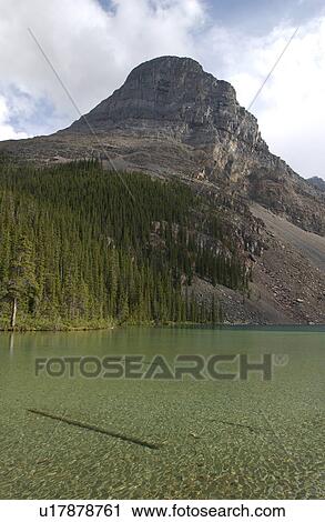 A lake at the foot a mountain, Rocky Mountains, Canada View Large Photo Image Stock Image - A lake at the foot a mountain, Rocky Mountains, Canada. Fotosearch