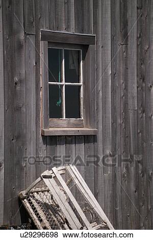 Stock Photo - Lobster trap leaning against a wooden cabin wall in Prince Edward Island, Canada. Fotosearch