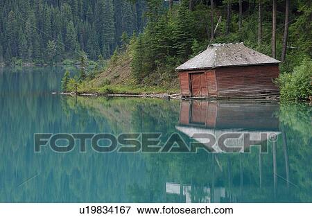 Stock Photo - View of a cottage on a lake, Rocky Mountains, Canada. Fotosearch