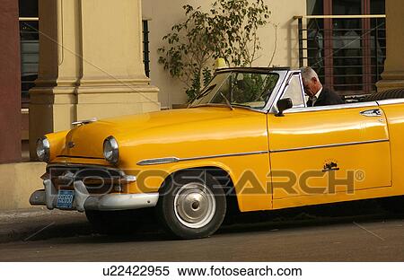 A convertible car parked in front of a building, Havana, Cuba View Large Photo Image Stock Photography - A convertible car parked in front of a building, Havana, Cuba. Fotosearch