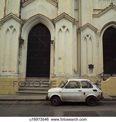 Stock Photograph - Compact car parked outside a building, Havana, Cuba. Fotosearch