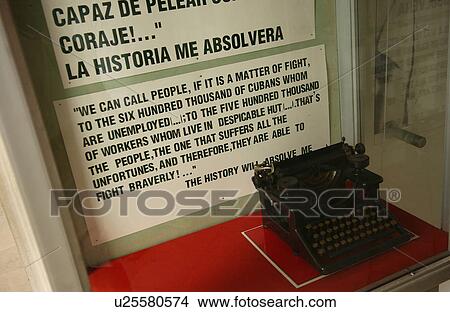 Picture - High angle view of a vintage typewriter in front of a protest poster, Havana, Cuba. Fotosearch