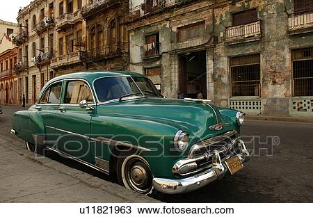 Stock Image - A car parked in front of a building, Havana, Cuba. Fotosearch
