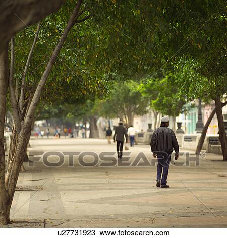 Rear view of people walking on the sidewalk, Havana, Cuba View Large Photo Image Stock Image - Rear view of people walking on the sidewalk, Havana, Cuba. Fotosearch