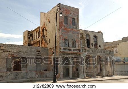Stock Photo - View of the facade of an abandoned commercial building, Havana, Cuba. Fotosearch