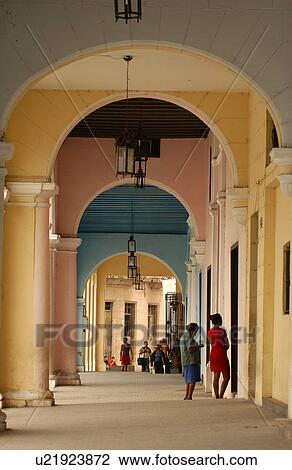 Stock Image - Group of people in a arched corridor, Havana, Cuba. Fotosearch