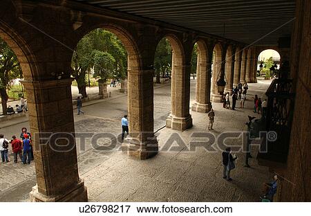 Stock Photo - High angle view of people in an arched corridor of a building, Havana, Cuba. Fotosearch